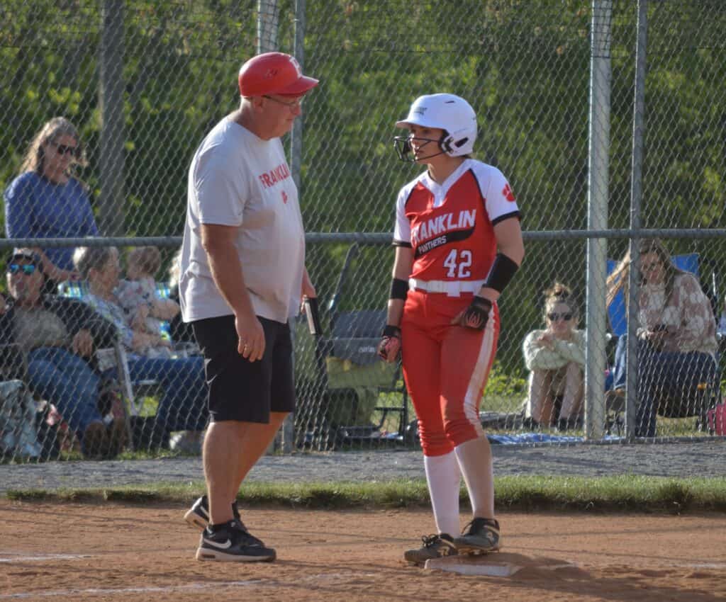 FHS softball player and coach discussing strategy during conference game.