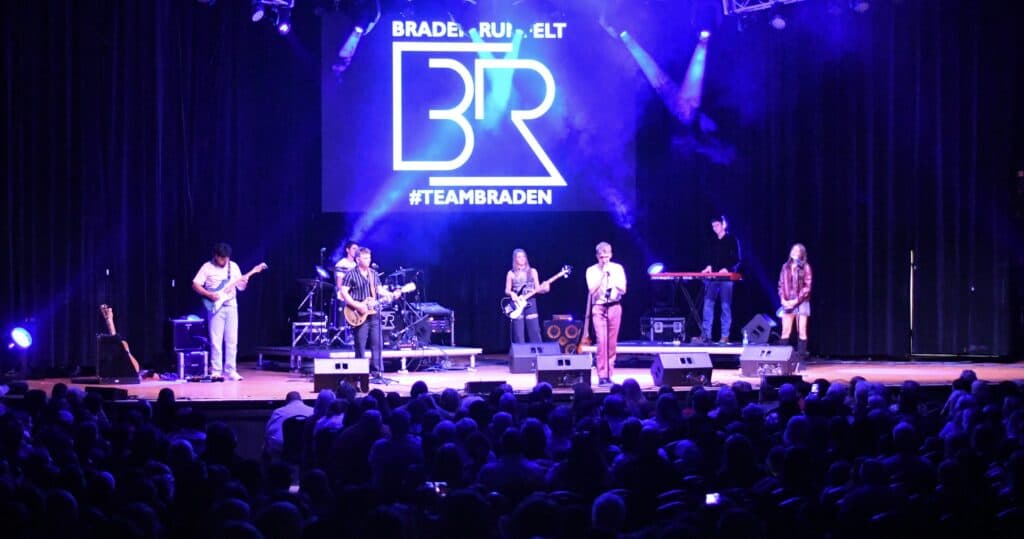 Macon Sense band performing on stage during a concert event.