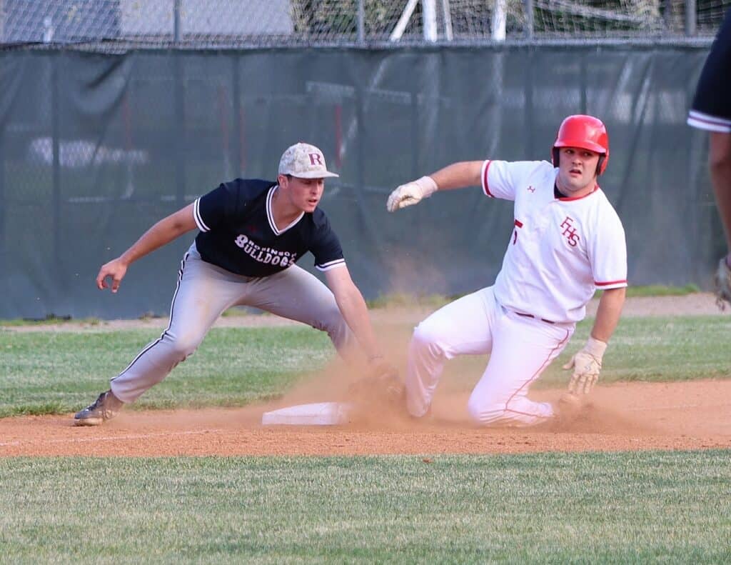 Baseball player sliding into base during playoff game at Macon Sense.