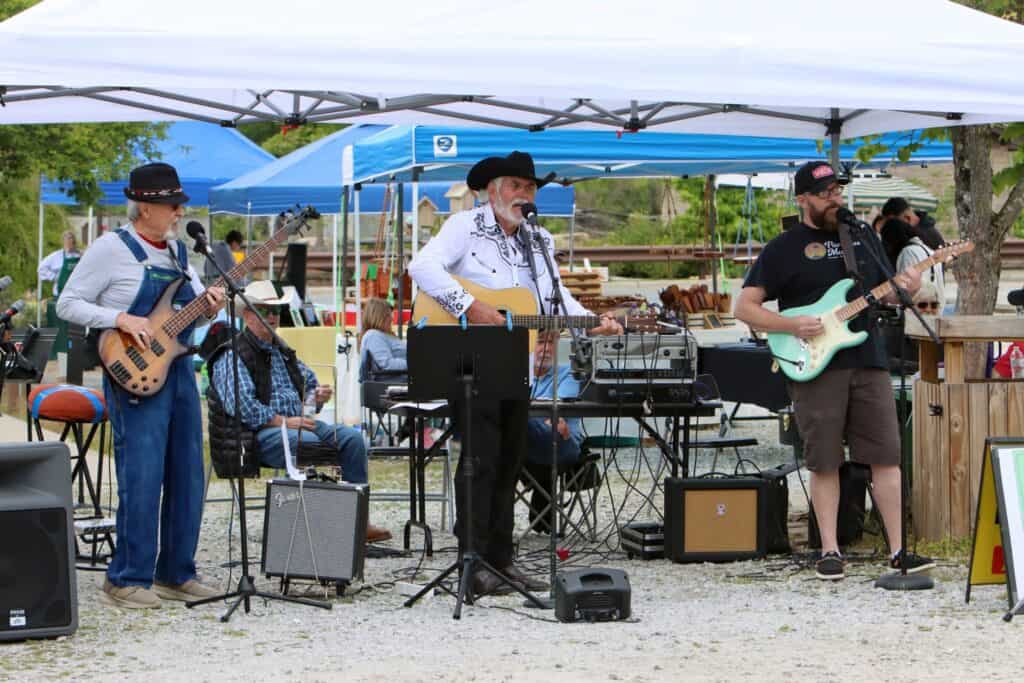 Live band performing at a spring festival with guitars and drums.