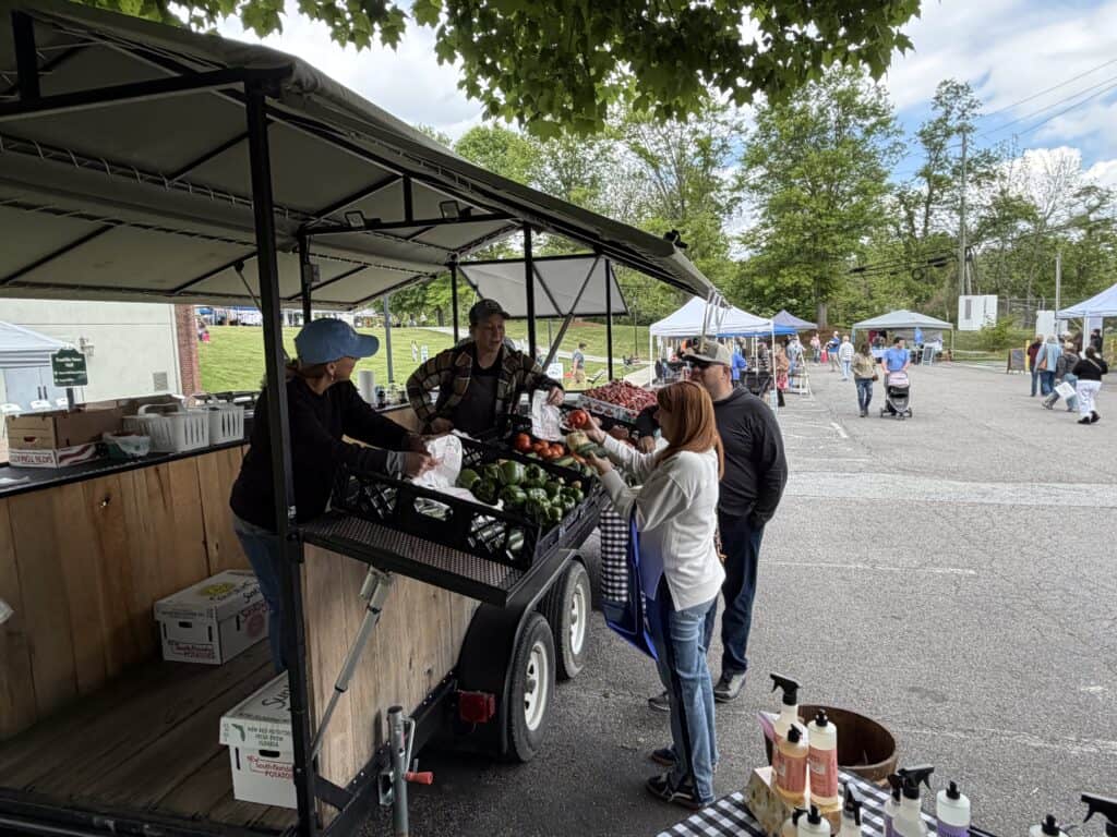 People shopping for fresh vegetables at Macon Sense Farmers Market.
