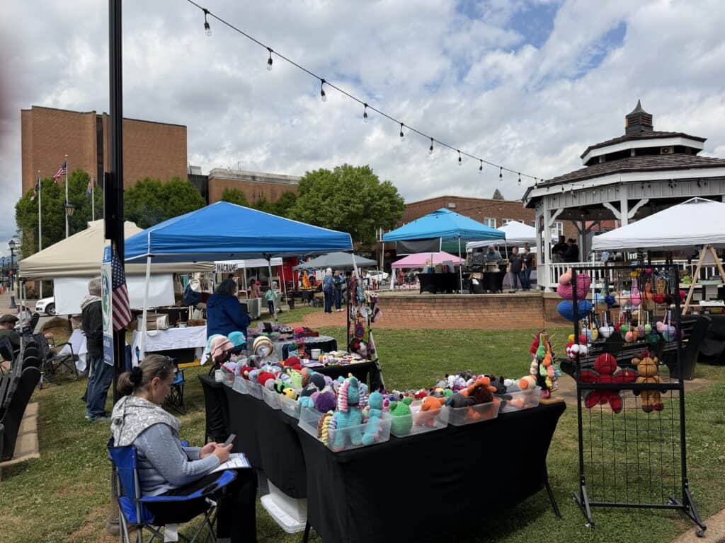 Vibrant outdoor market with colorful handmade crafts and vendors under tents in Macon, Georgia.