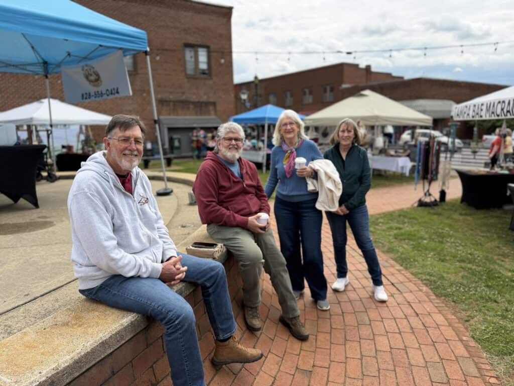 Group of four people enjoying outdoor market at Macon Sense event.