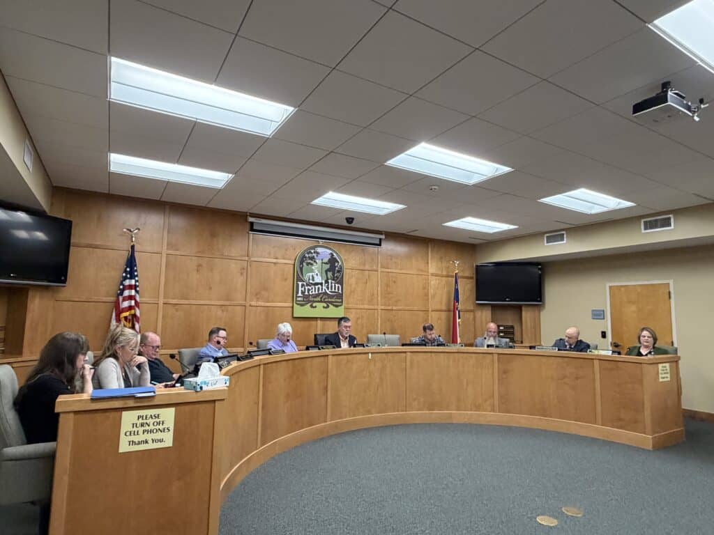 Macon City Council members seated at a curved table during a formal meeting.