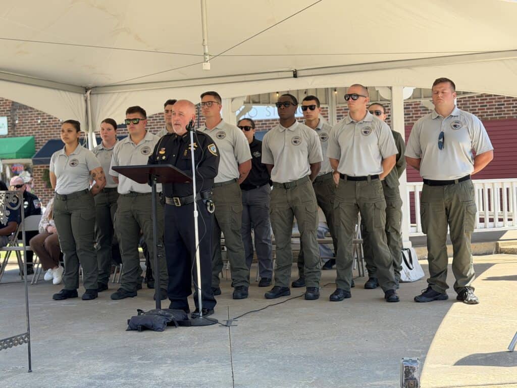 Group of police officers standing in formation during a public ceremony outdoors.