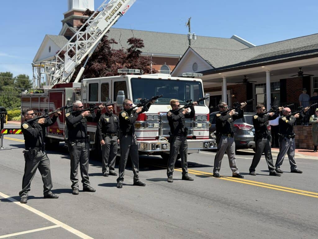 Emergency response team practicing firearm drills outside fire station.
