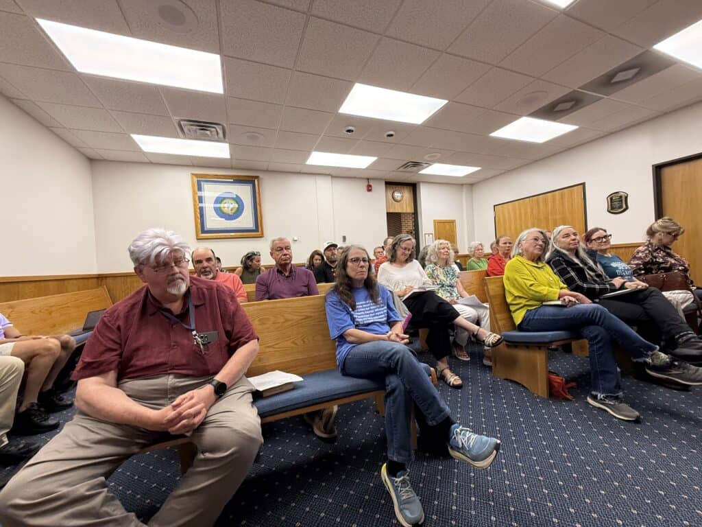 Community meeting with diverse attendees in a conference room at Macon Sense.