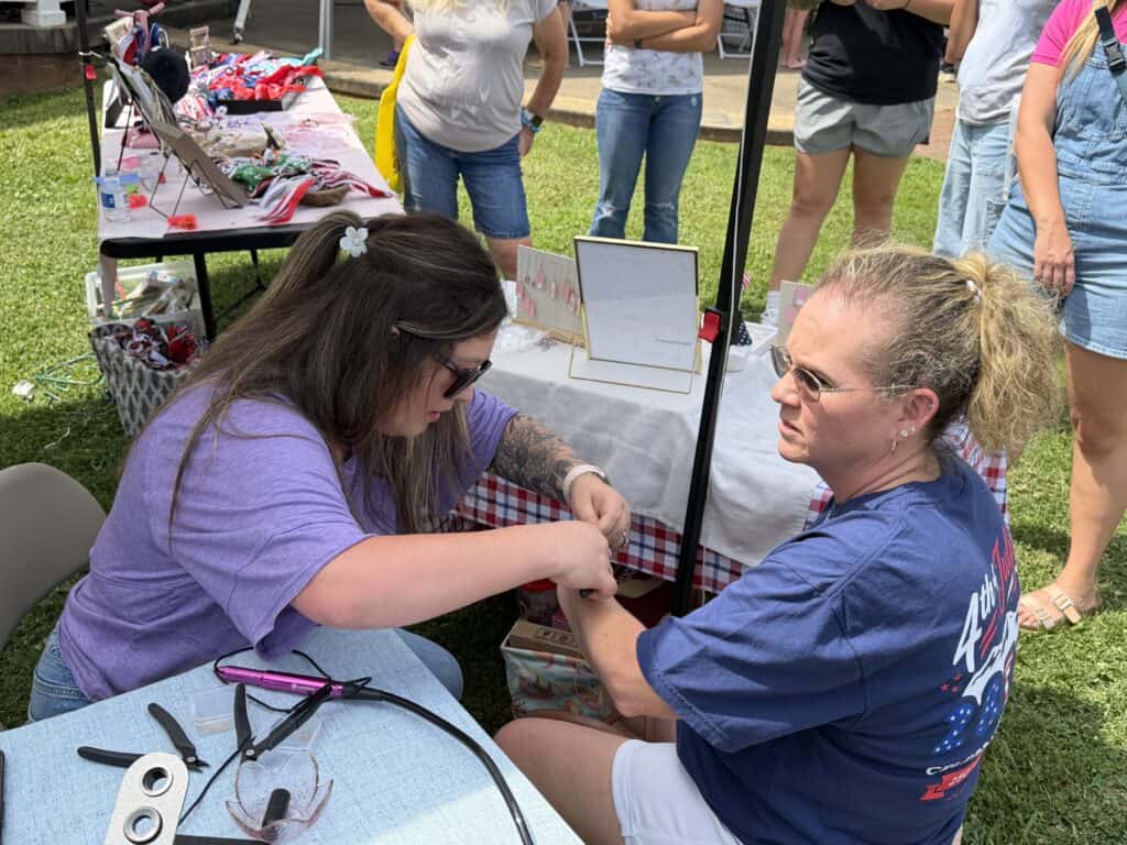 Woman receiving blood pressure check at outdoor health event.