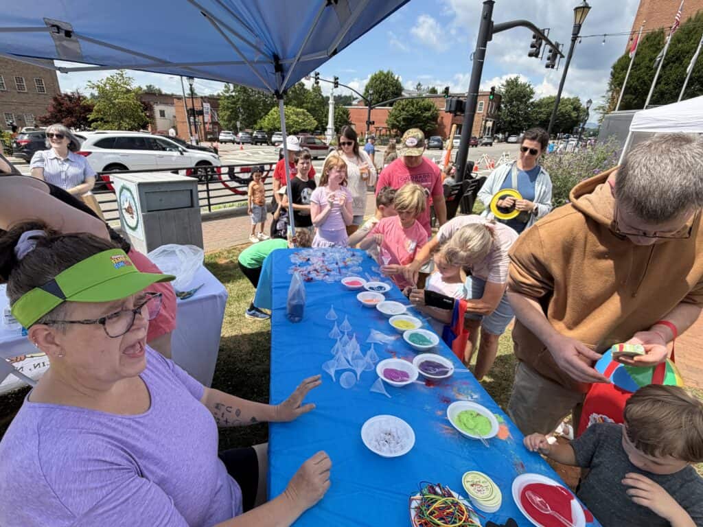 People enjoying a community outdoor event with arts and crafts activities.