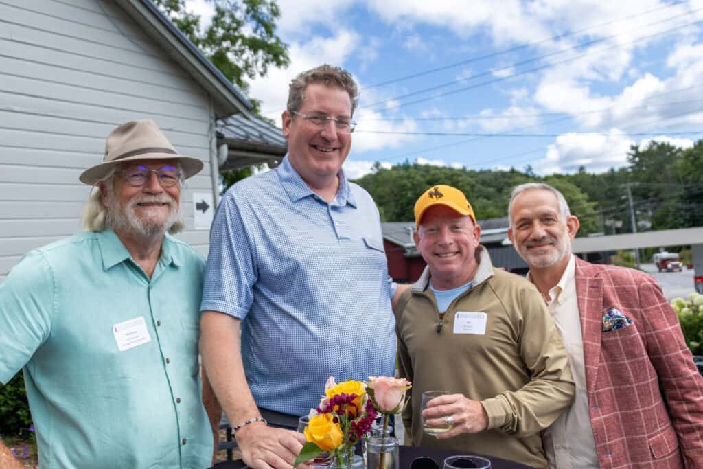 Group of four men smiling at outdoor networking event in Highlands.