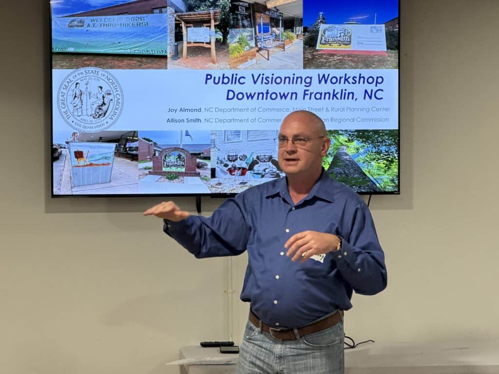 Man presenting at Franklin public visioning workshop with display screen behind him.