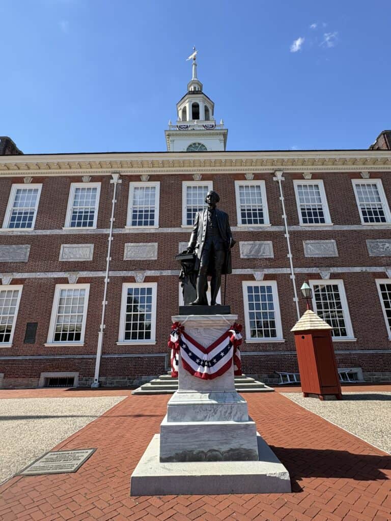 Statue of Thomas Jefferson in front of Independence Hall, Philadelphia, on a sunny day.