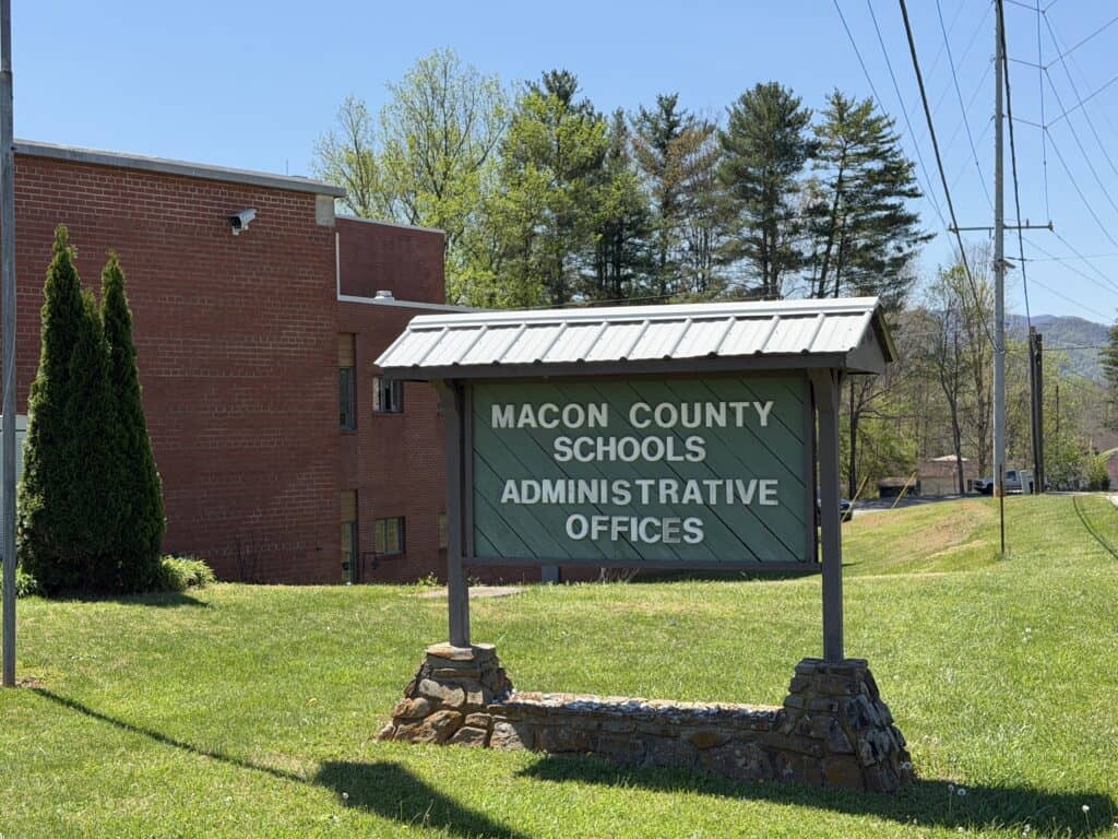 Sign for Macon County Schools Administrative Offices in a grassy area.