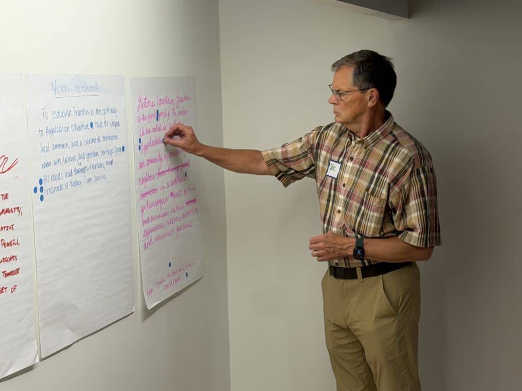 Man presenting ideas on community future at Franklin meeting.