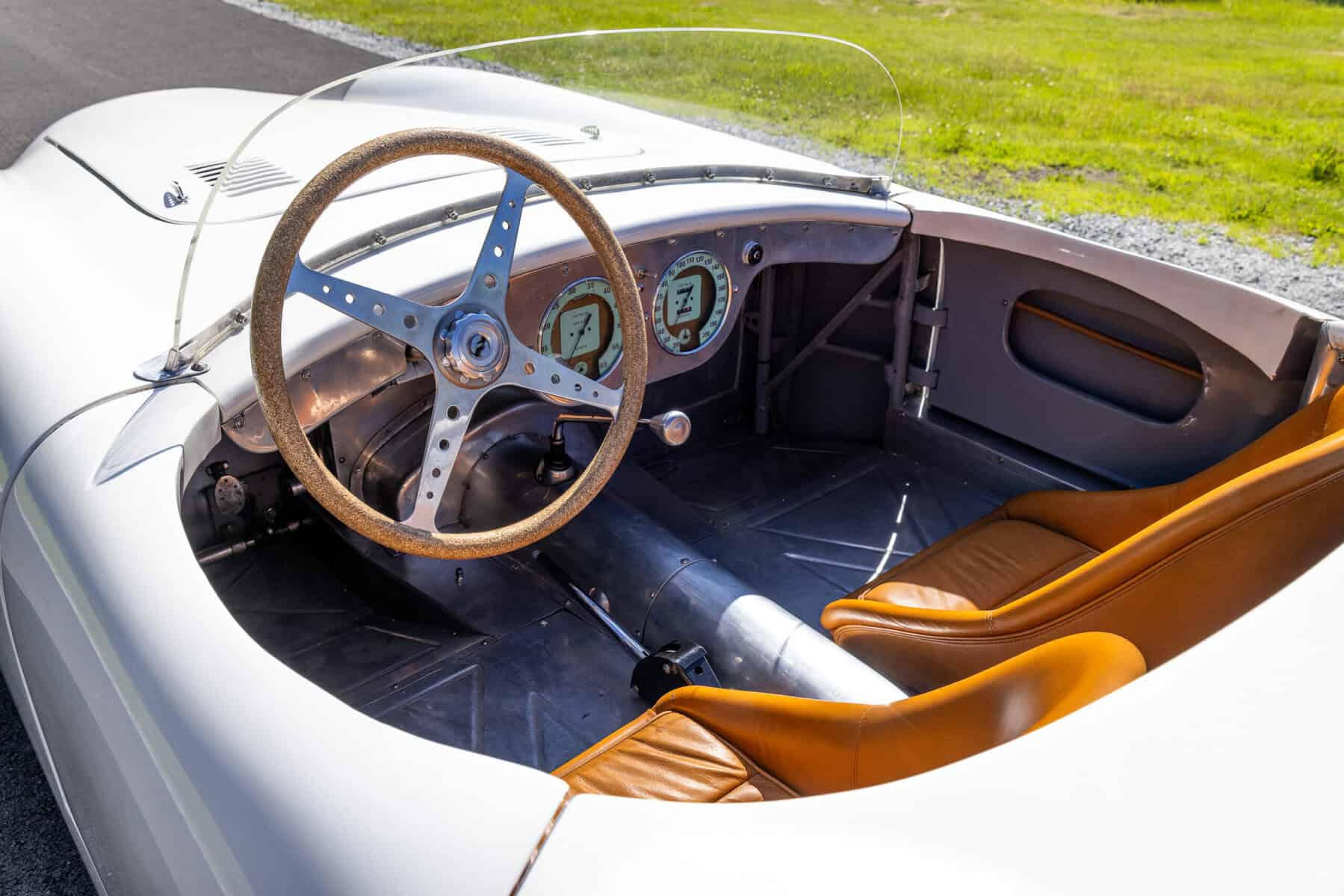 Classic vintage car interior with steering wheel and dashboard details.