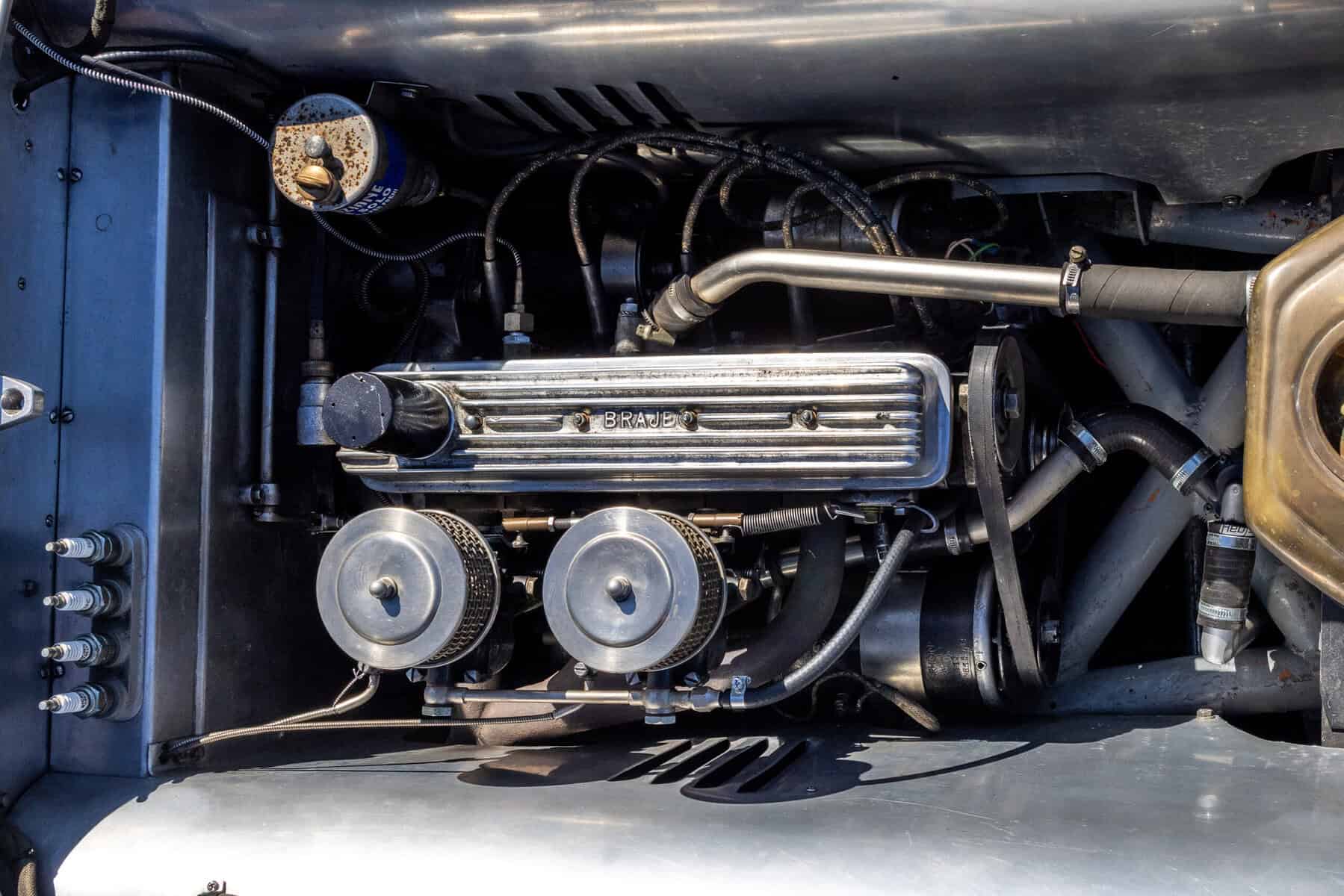 Vintage car engine with detailed mechanical parts and metallic finish.