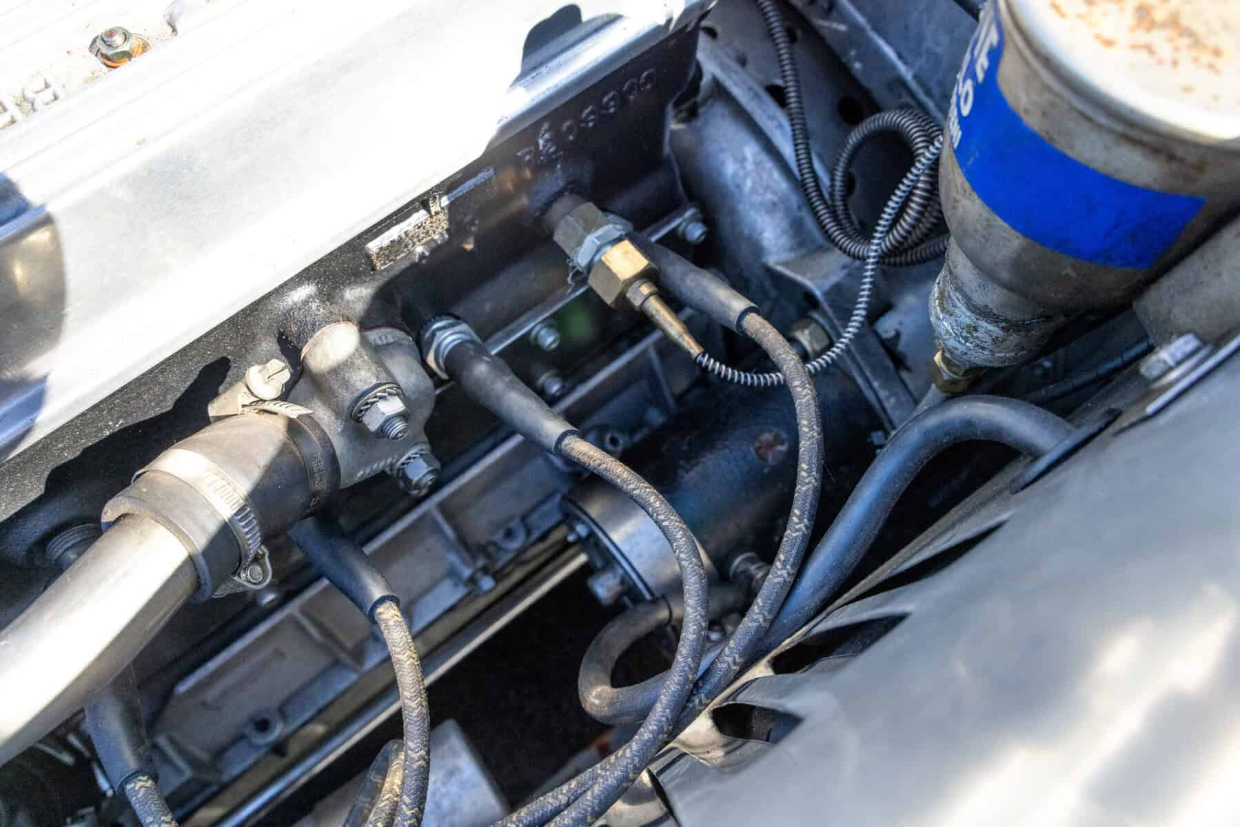 Close-up of car engine parts and hoses in detailed view.