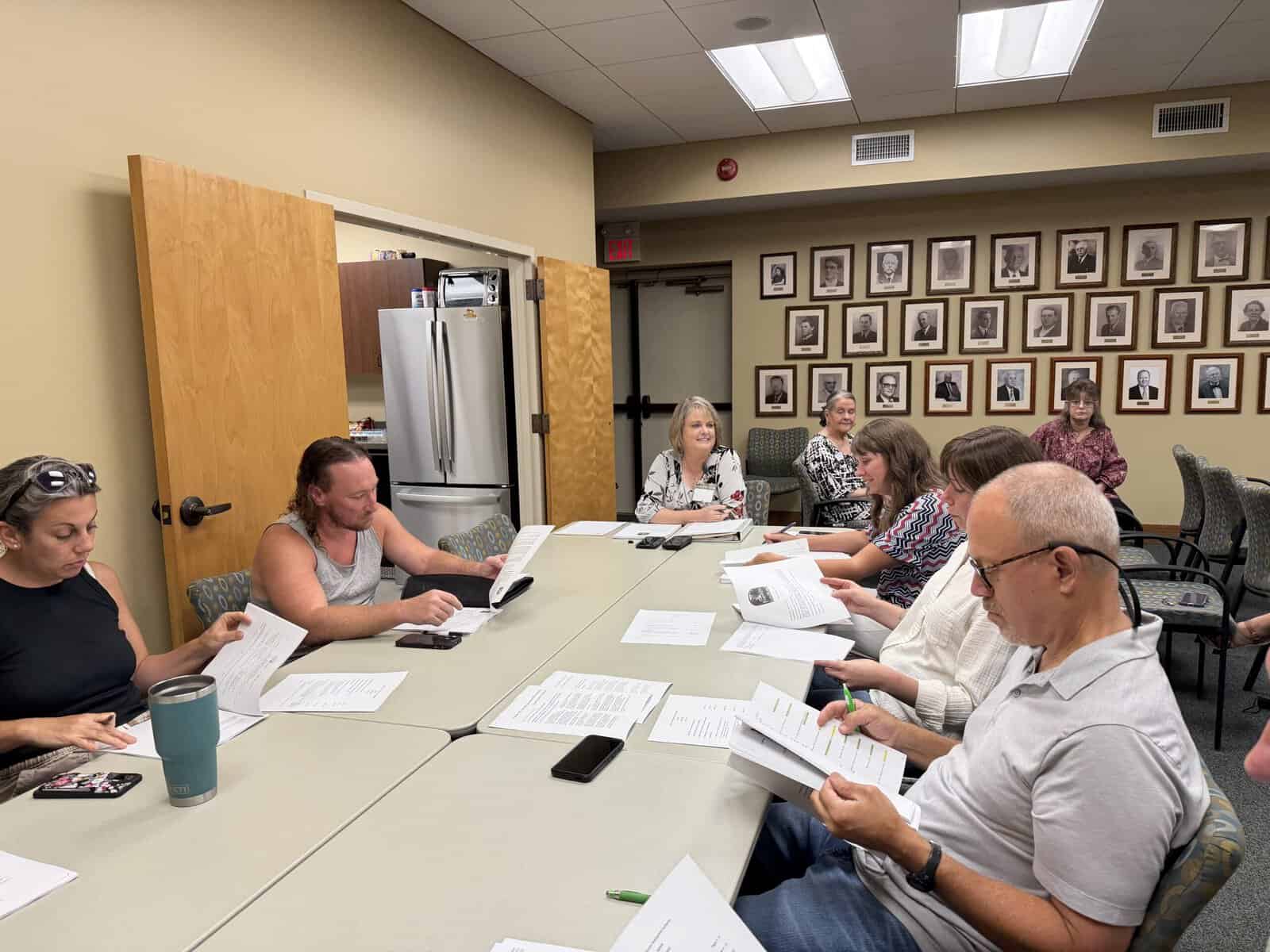 Local officials discuss tourism development plans in a meeting room.