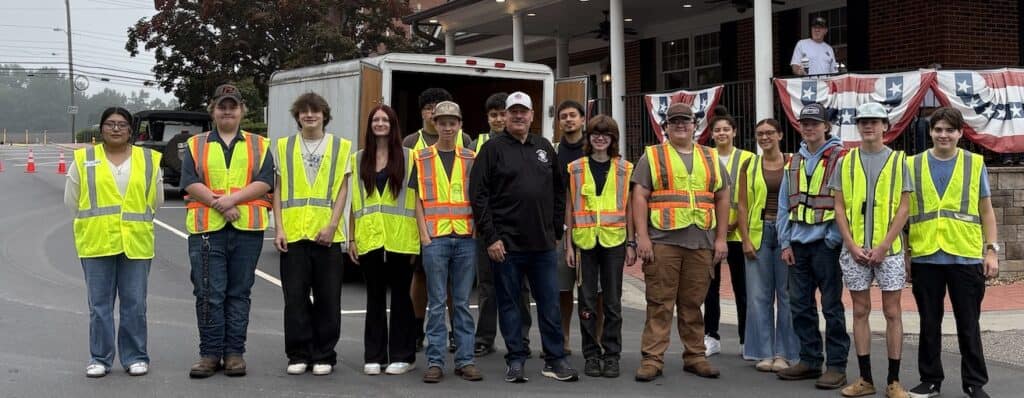 Group of veterans and volunteers wearing safety vests at a community event.