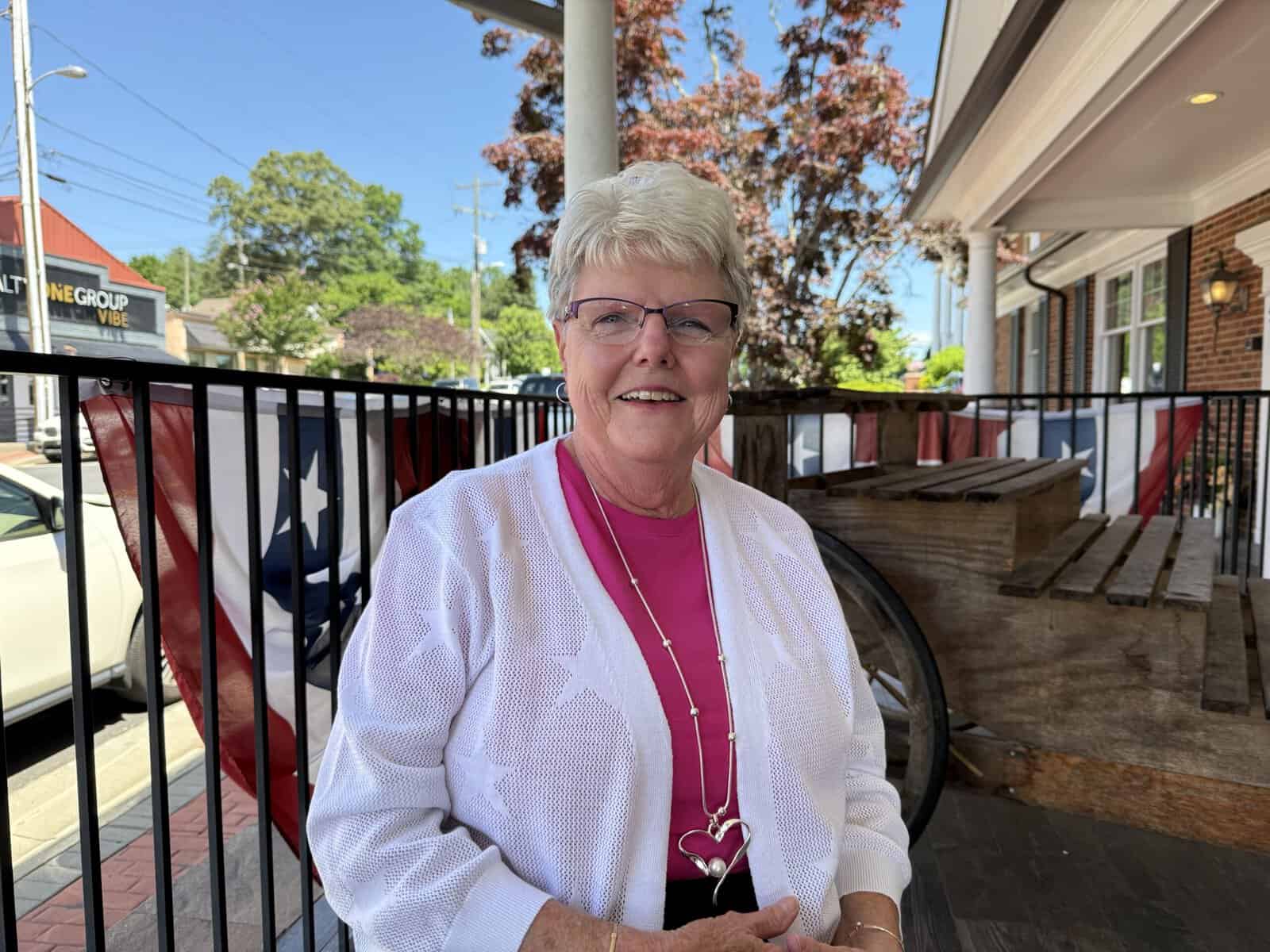Senior woman smiling outdoors, supporting senior care initiatives.