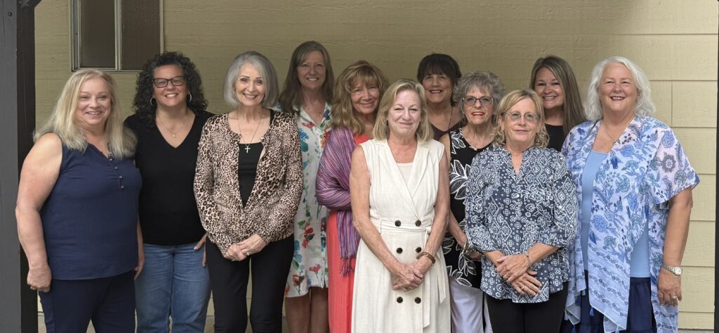 Diverse group of women smiling at a community gathering.