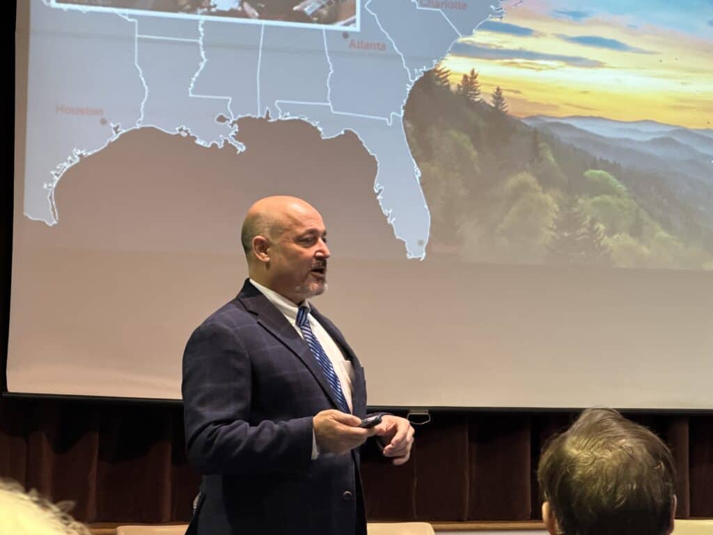 Speaker presenting U.S. map and landscape at Macon Sense event.