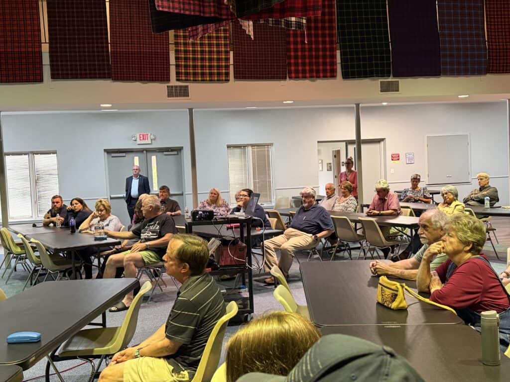 Group of diverse people attending a community meeting in a conference room.