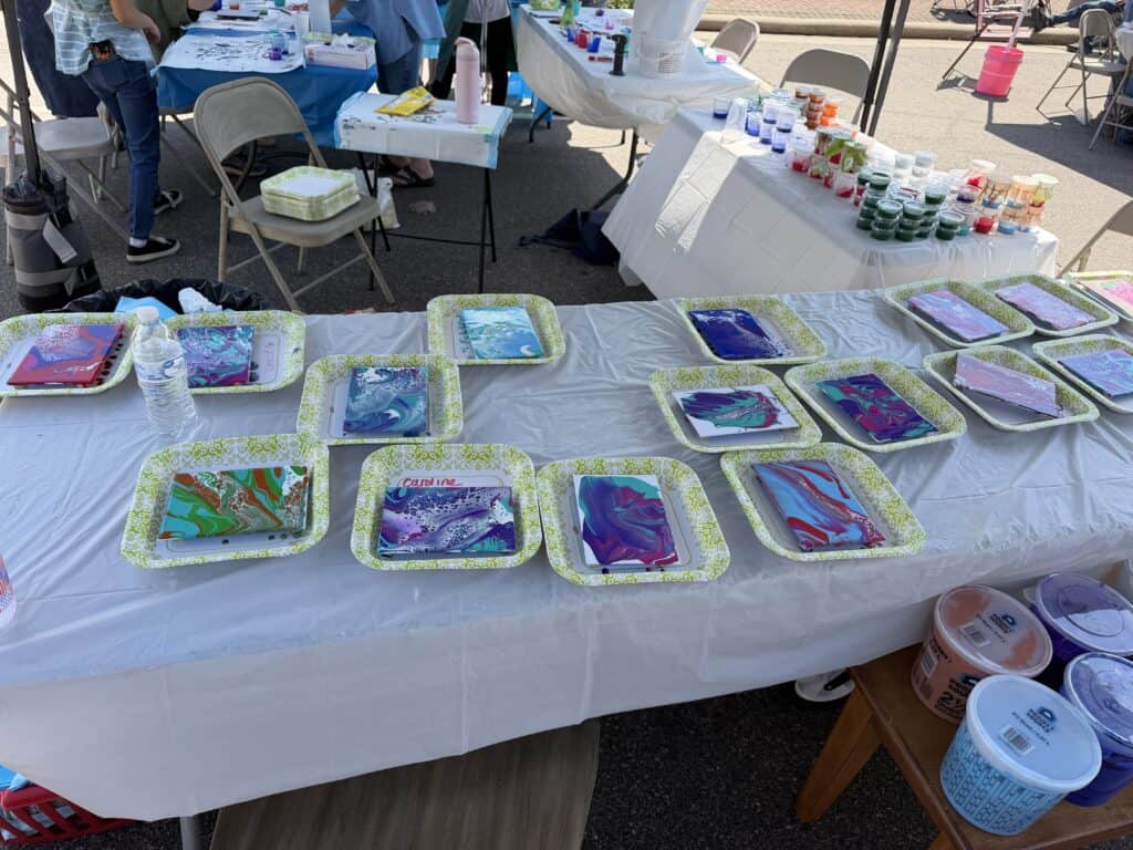 Colorful paint pouring art on display at Macon Sense event.