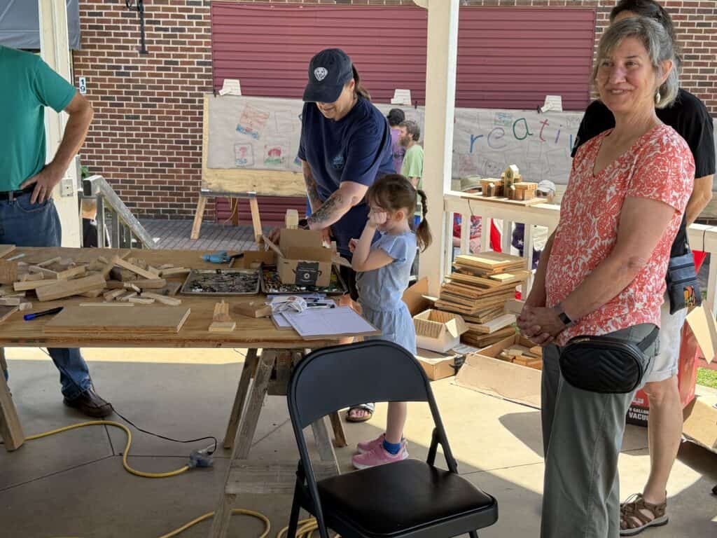 People participating in a woodworking workshop at Macon Sense event.