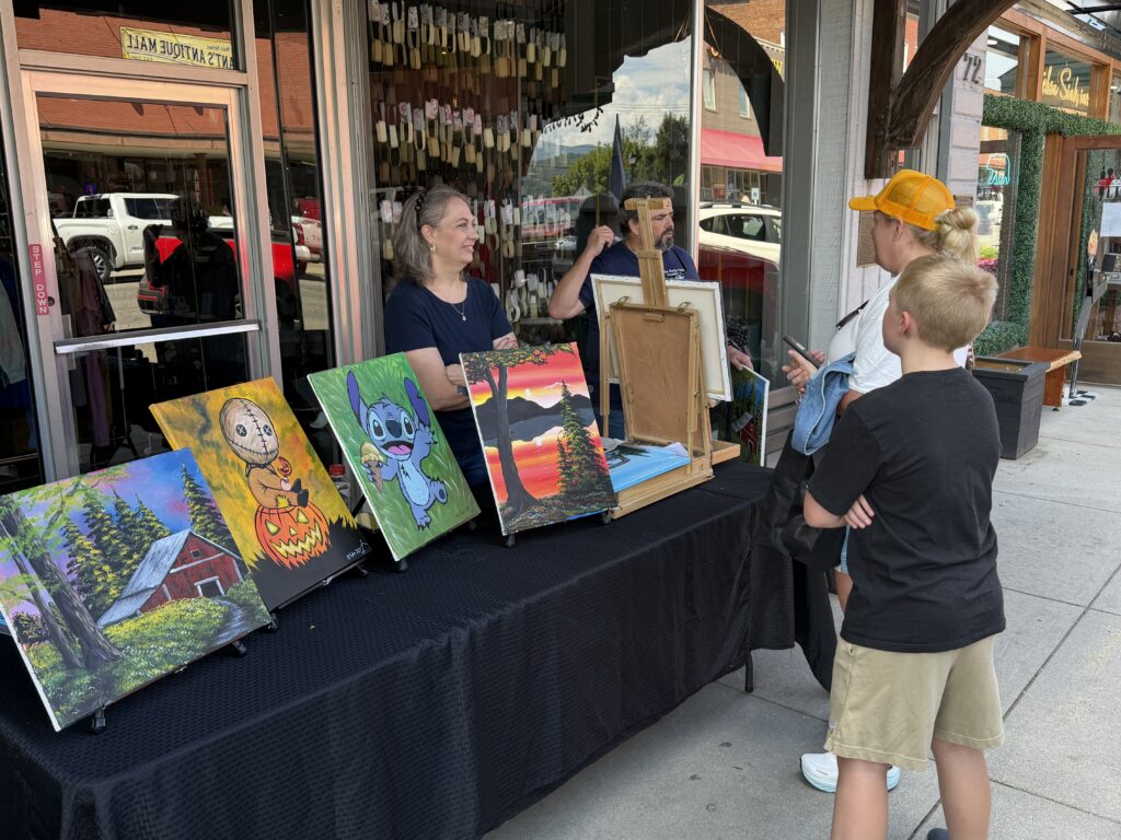 Artists showcase colorful paintings at ARTFEST downtown event.