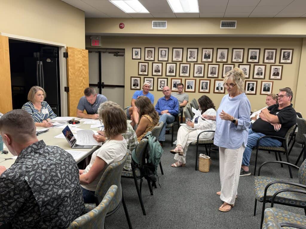 Group of diverse people attending a community meeting in a conference room.