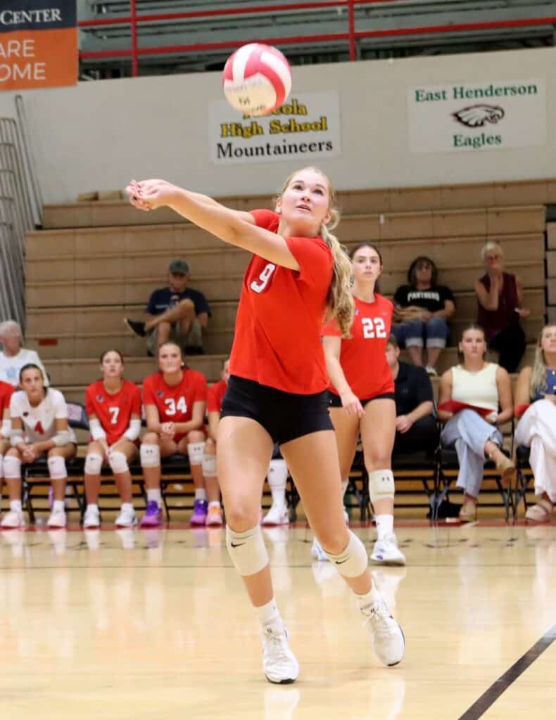 Young female volleyball player serving during a game at East Henderson High School.