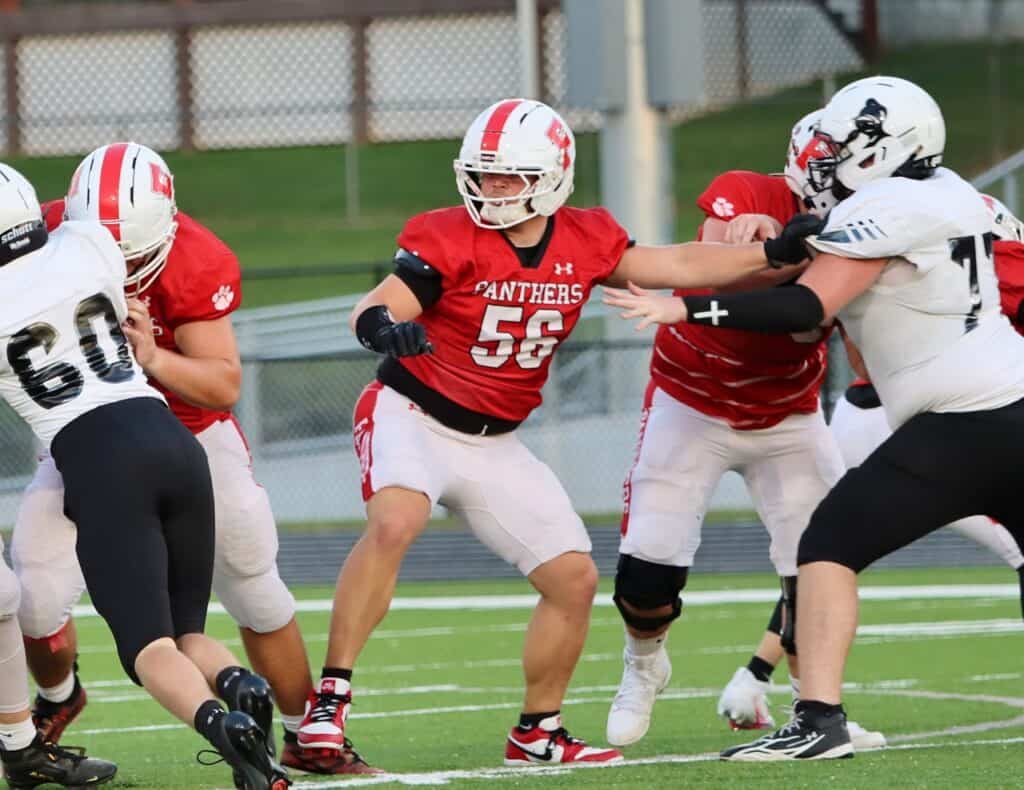 High school football players in red and white uniforms during game.