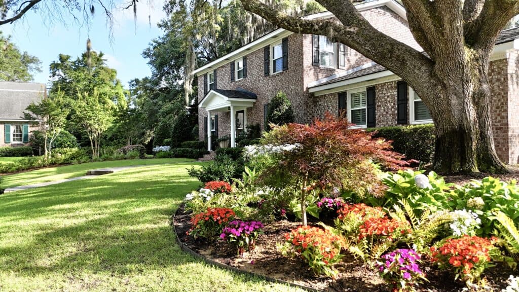 Colorful flower garden with lush greenery and mature trees in Western North Carolina.