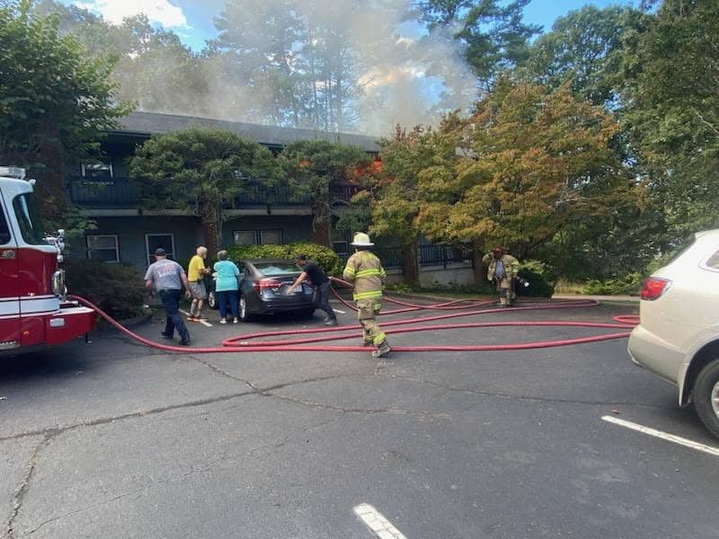Firefighters and emergency responders at Harrison Garden Apartments fire scene.
