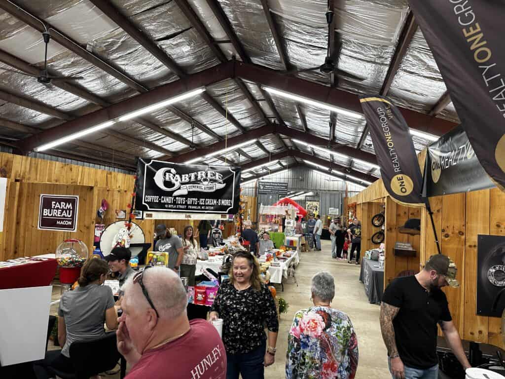 Indoor market scene with vendors and shoppers at Macon Sense event.