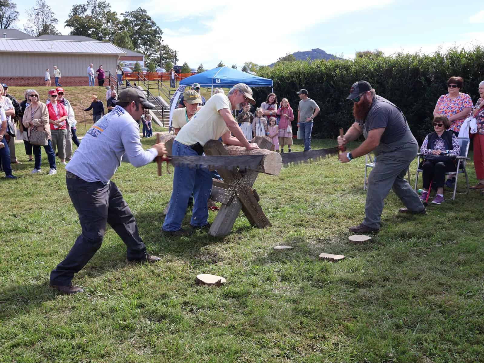 People participating in a traditional wood chopping contest at Mountaineer Festival.