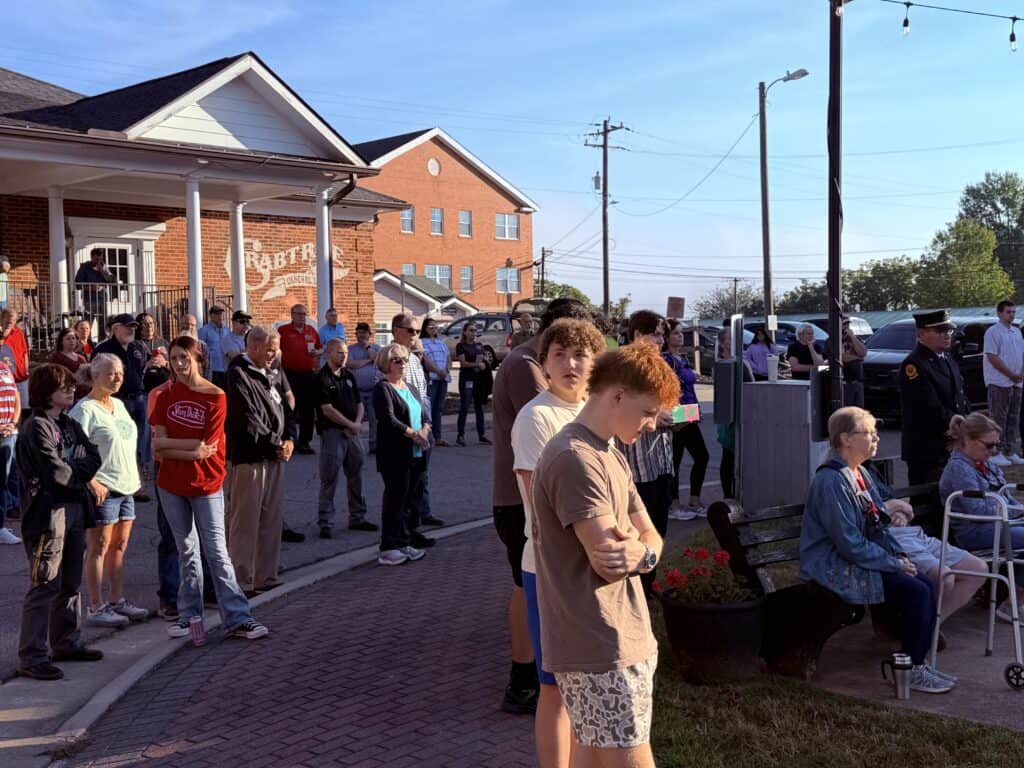 People gathered outside a brick building in Macon for a community event.