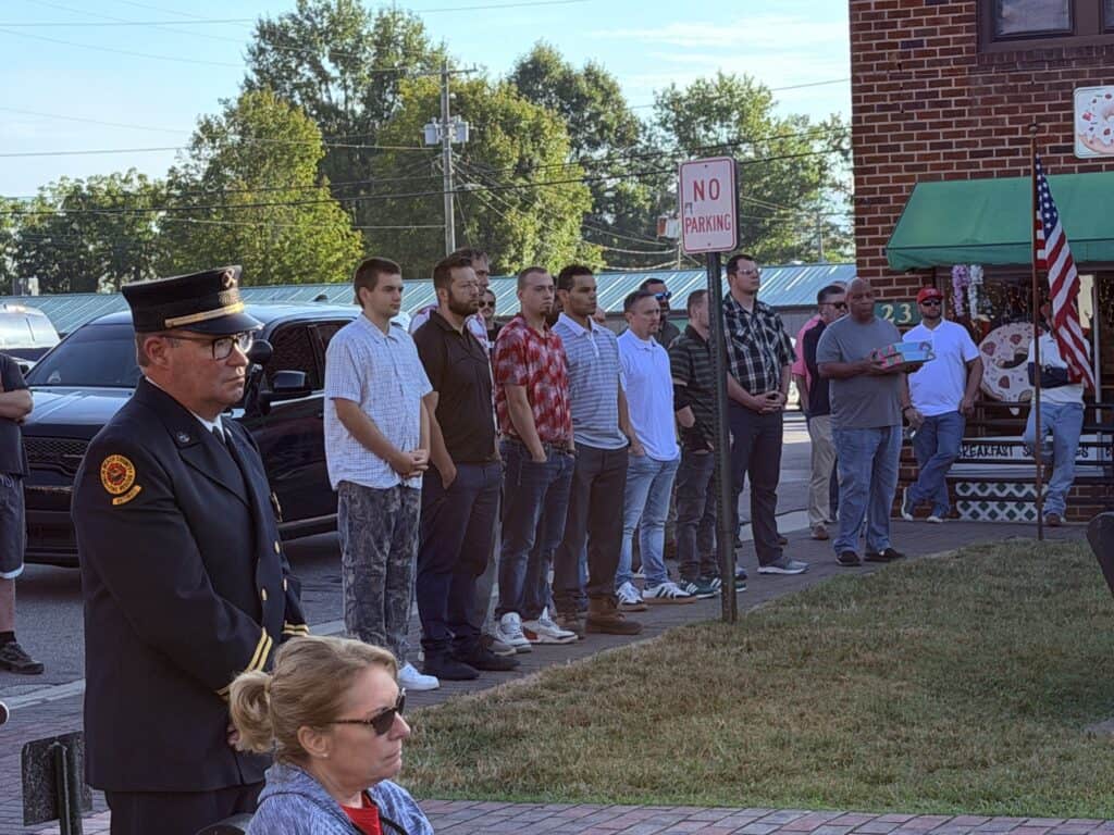 People gather for a memorial event outside a brick building in Macon, Georgia.