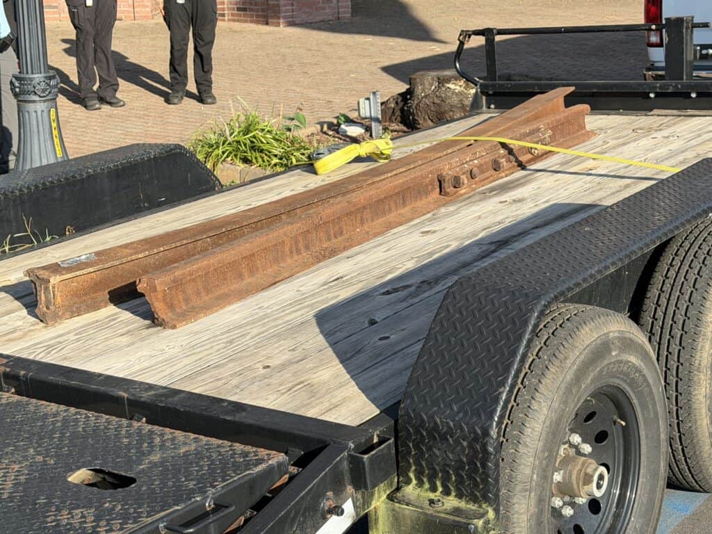 Rusty steel beam loaded on a flatbed trailer for transport.