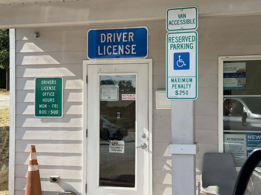 Driver license office entrance with parking and accessibility signs.