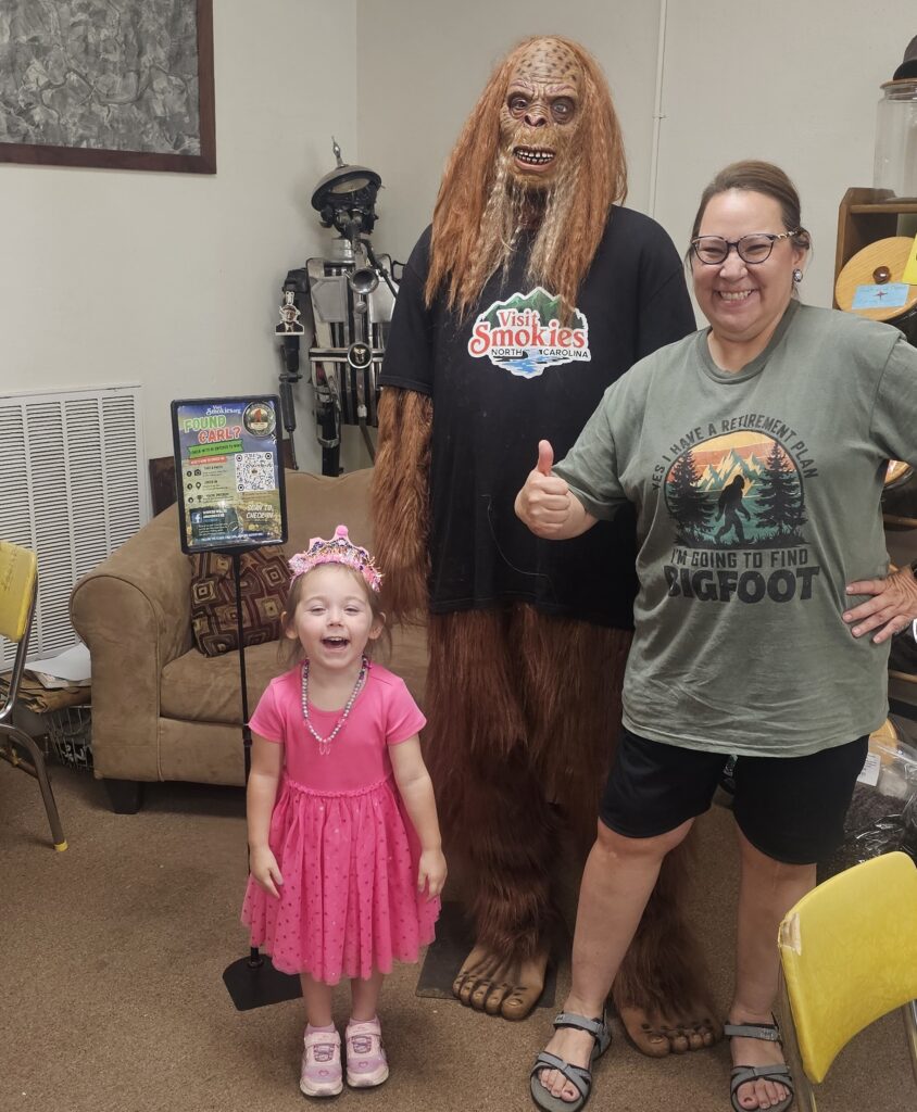 Family with Bigfoot mascot at Smokies' Sasquatch Hunt event in WNC.