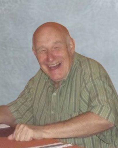 Happy elderly man laughing, wearing a striped shirt, sitting at a table.