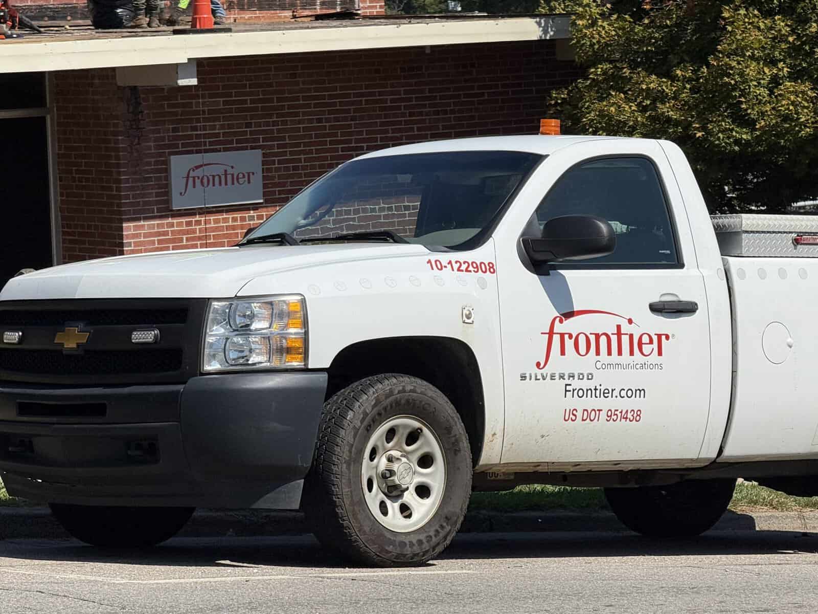 Frontier Communications service truck parked outside a building.