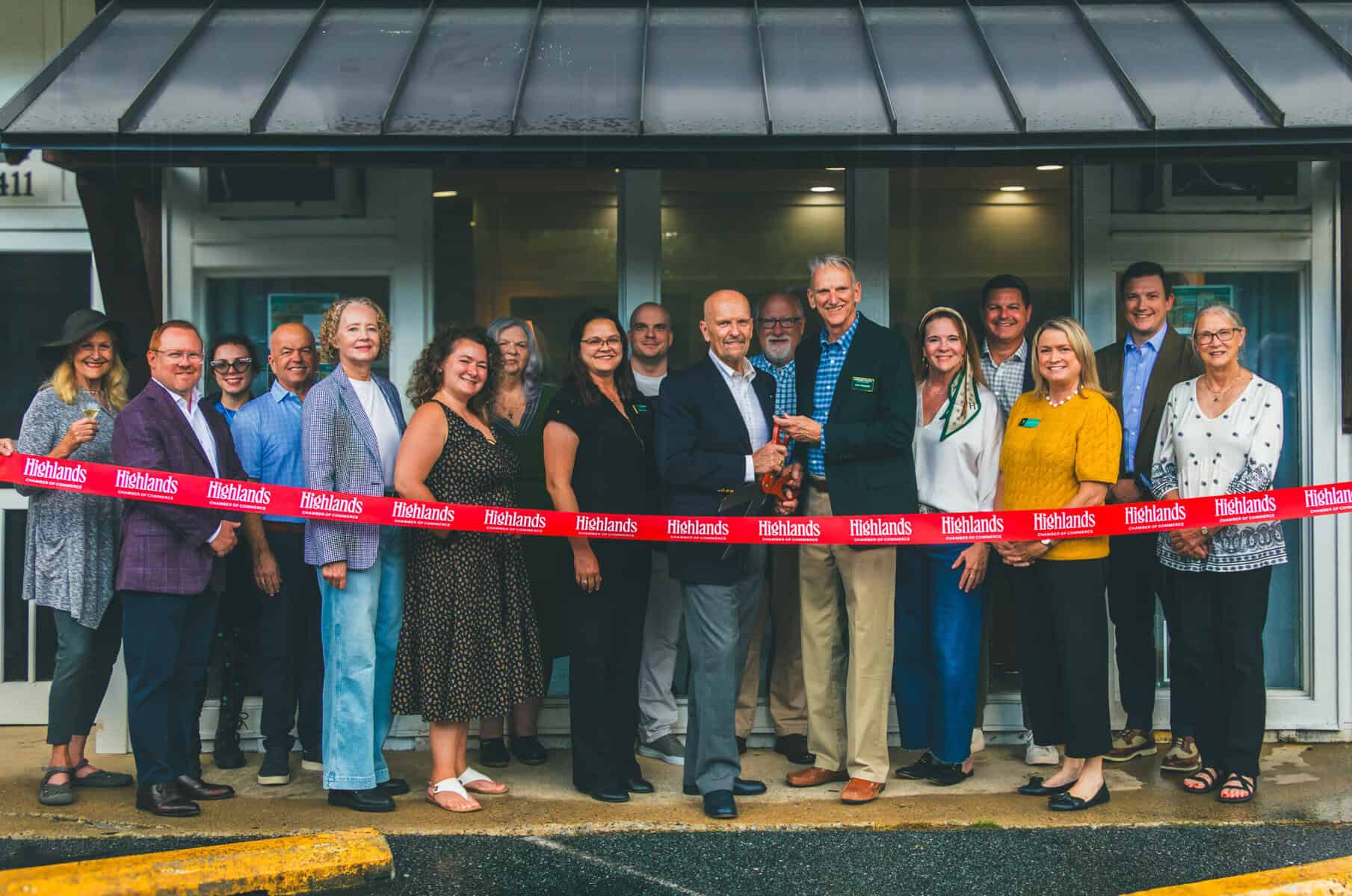 Group of professionals at Highlands office opening ribbon-cutting event.