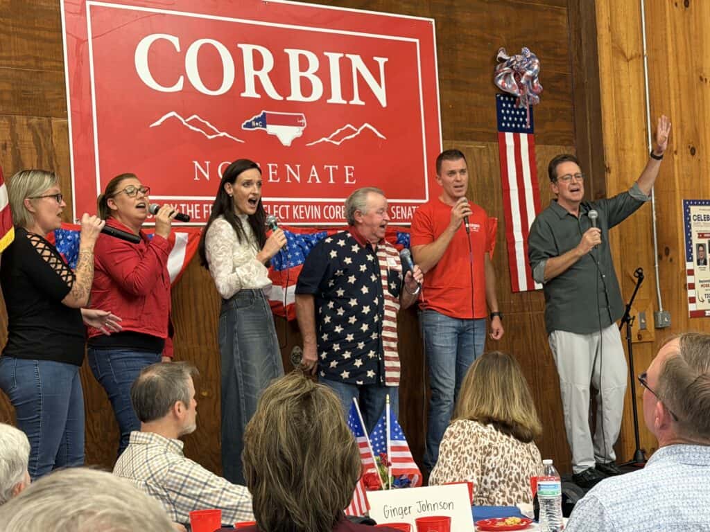 Group of people speaking at Corbin re-election campaign event.