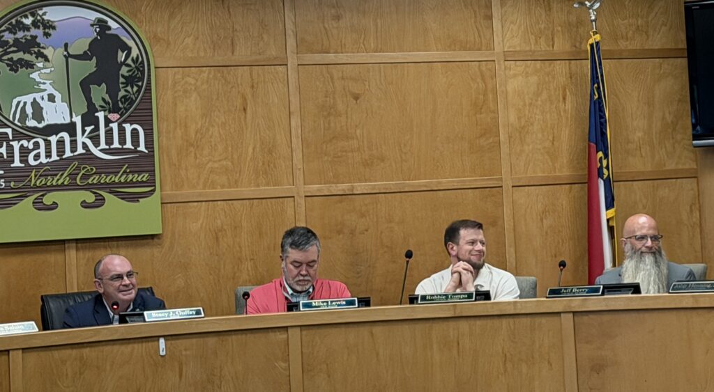 Franklin council members seated at a meeting table in a wood-paneled room.