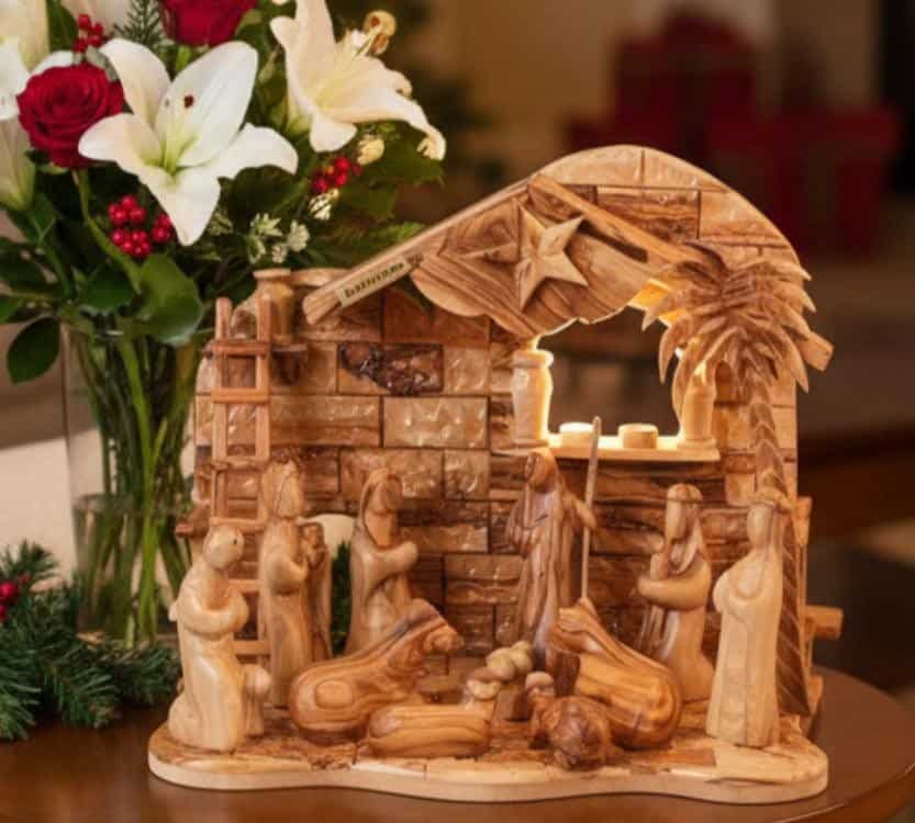Olive wood nativity sculpture with carved figures around the manger.