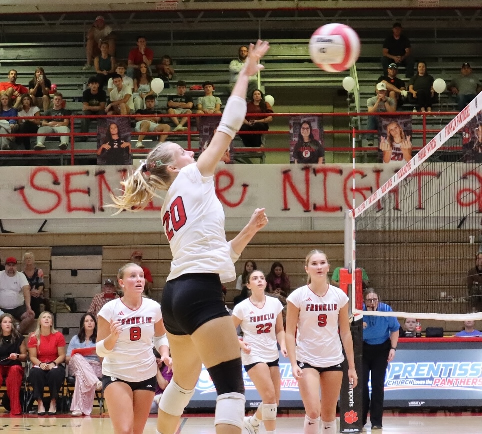 Girls volleyball player spiking the ball during a match at Macon Sense.