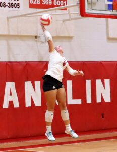 Volleyball player jumping to hit the ball during a game at Macon Sense.